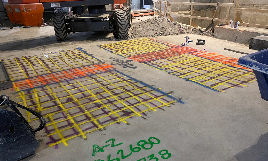 A tractor is sitting on top of a concrete surface with a grid drawn on it.