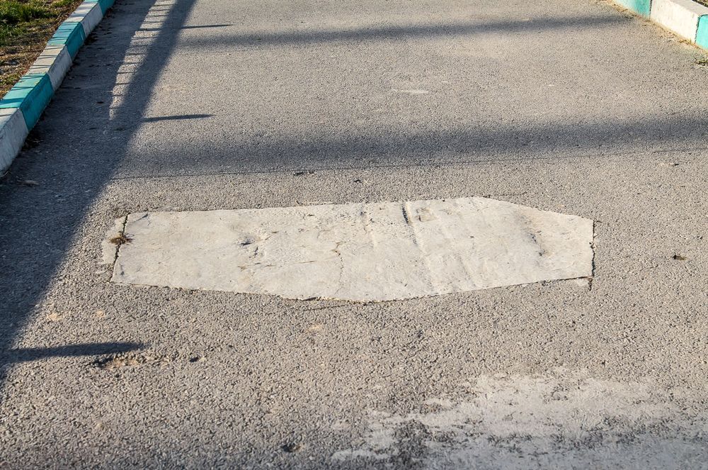 A patch of concrete in the middle of a road