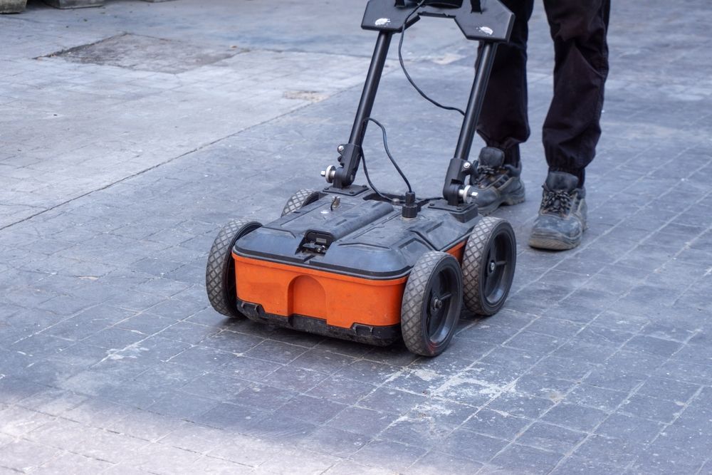 A person is using a robotic device on the ground.