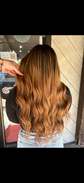 A woman is getting her hair cut by a hairdresser in a salon.