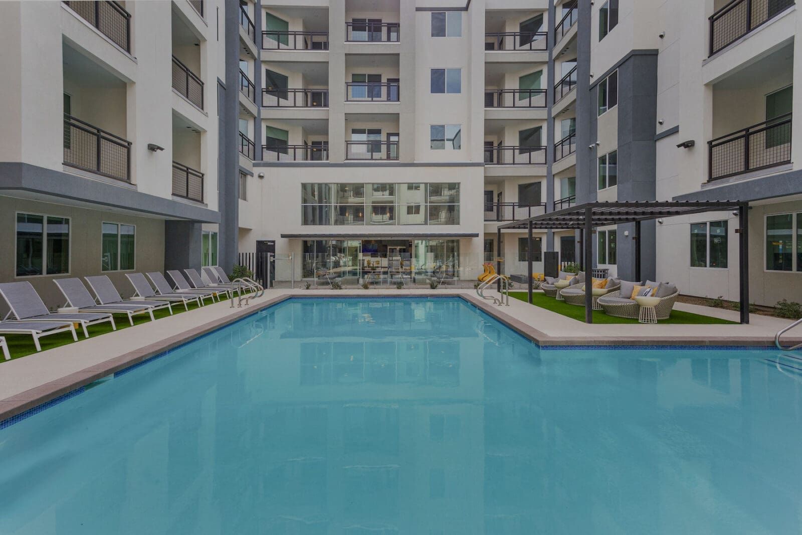 Outdoor swimming pool with lounge chairs and seating area at Echo Biltmore in Phoenix AZ.