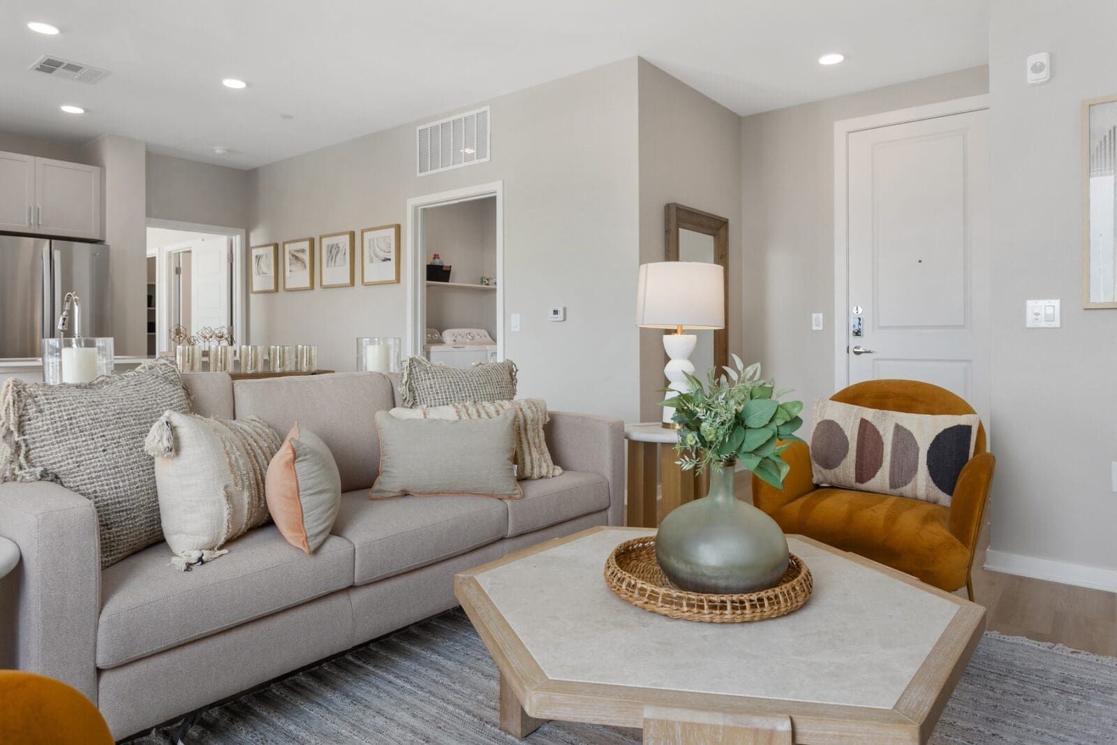 Cozy living room with a neutral-toned sofa, accent chair, coffee table, and artwork at Echo Biltmore in Phoenix AZ.