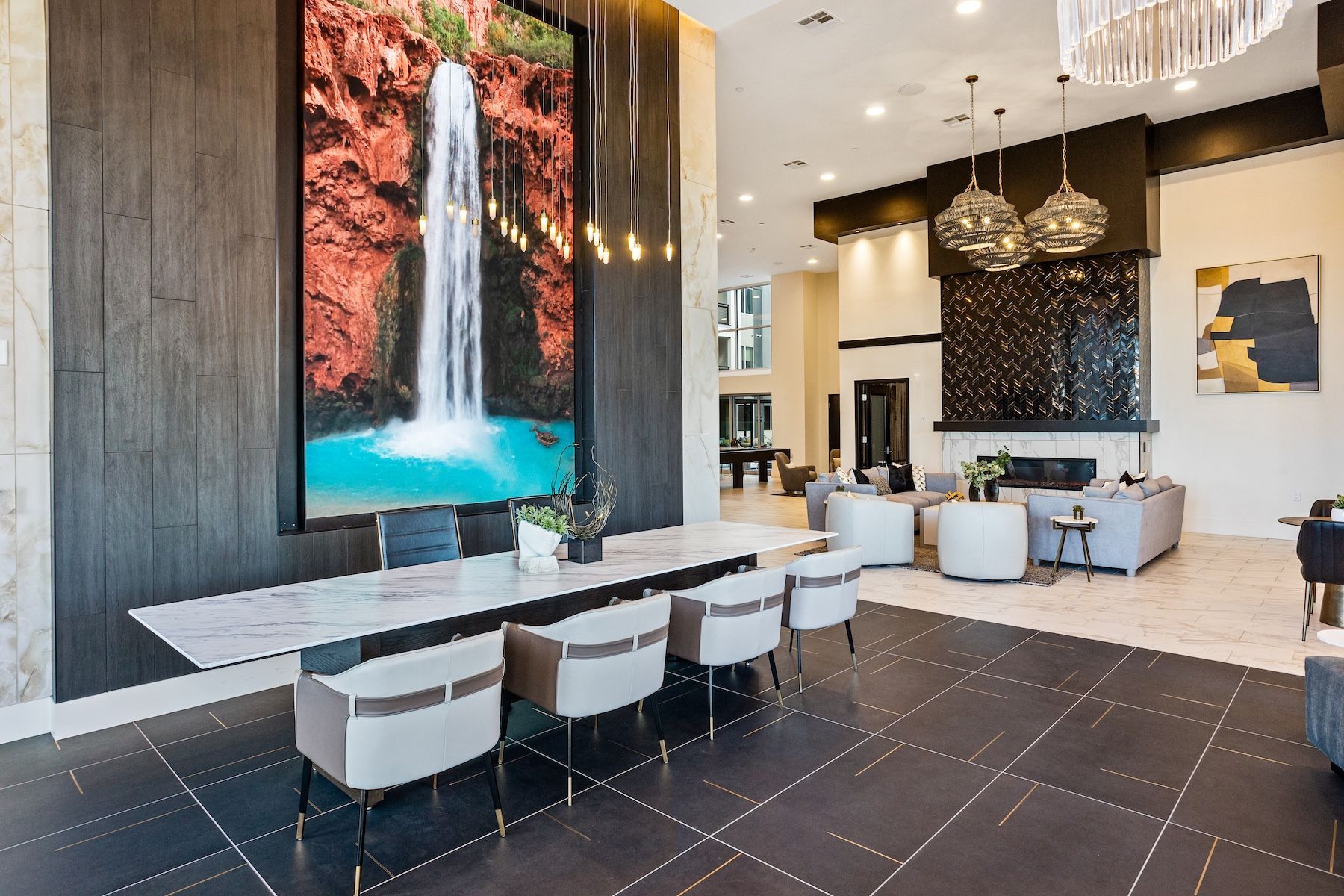 Modern apartment lounge area with large waterfall artwork and fireplace at Echo Biltmore in Phoenix AZ.