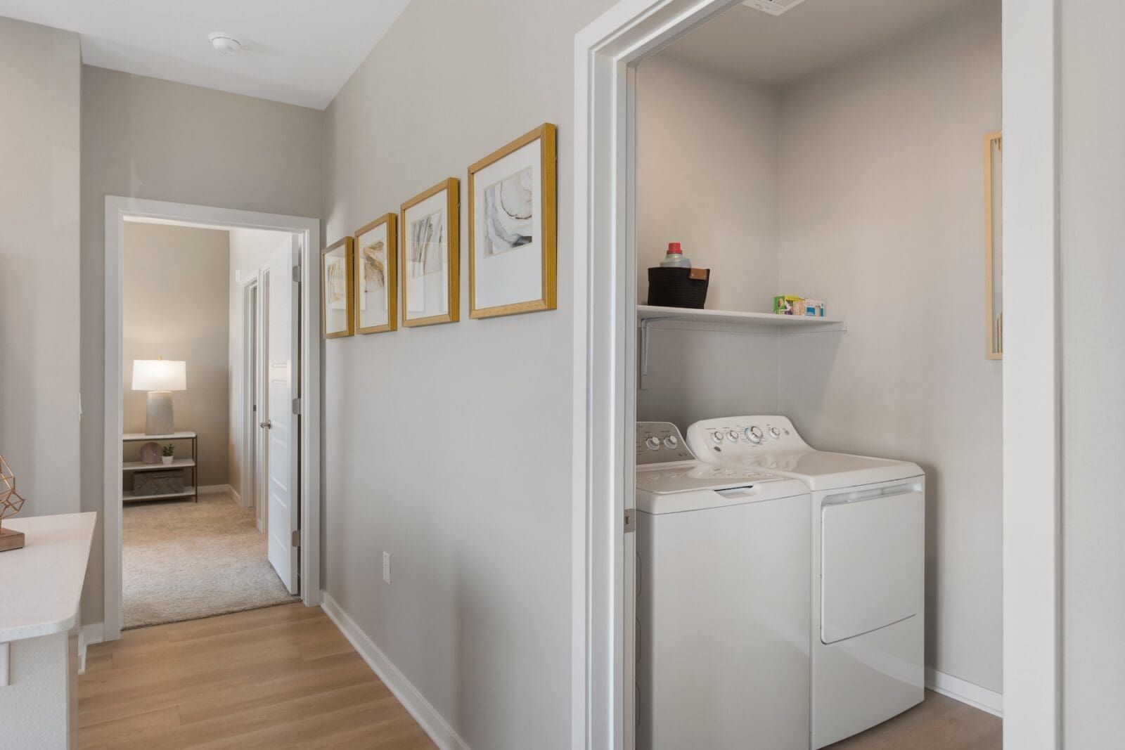 Hallway with a view into a laundry room featuring a washing machine and dryer at Echo Biltmore in Phoenix AZ.