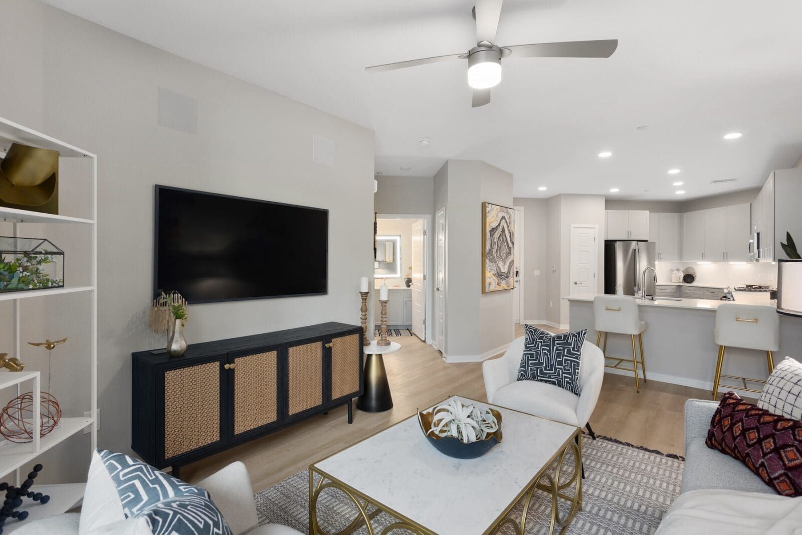 Modern living room and kitchen with white cabinets and stainless steel appliances at Echo Biltmore in Phoenix AZ.