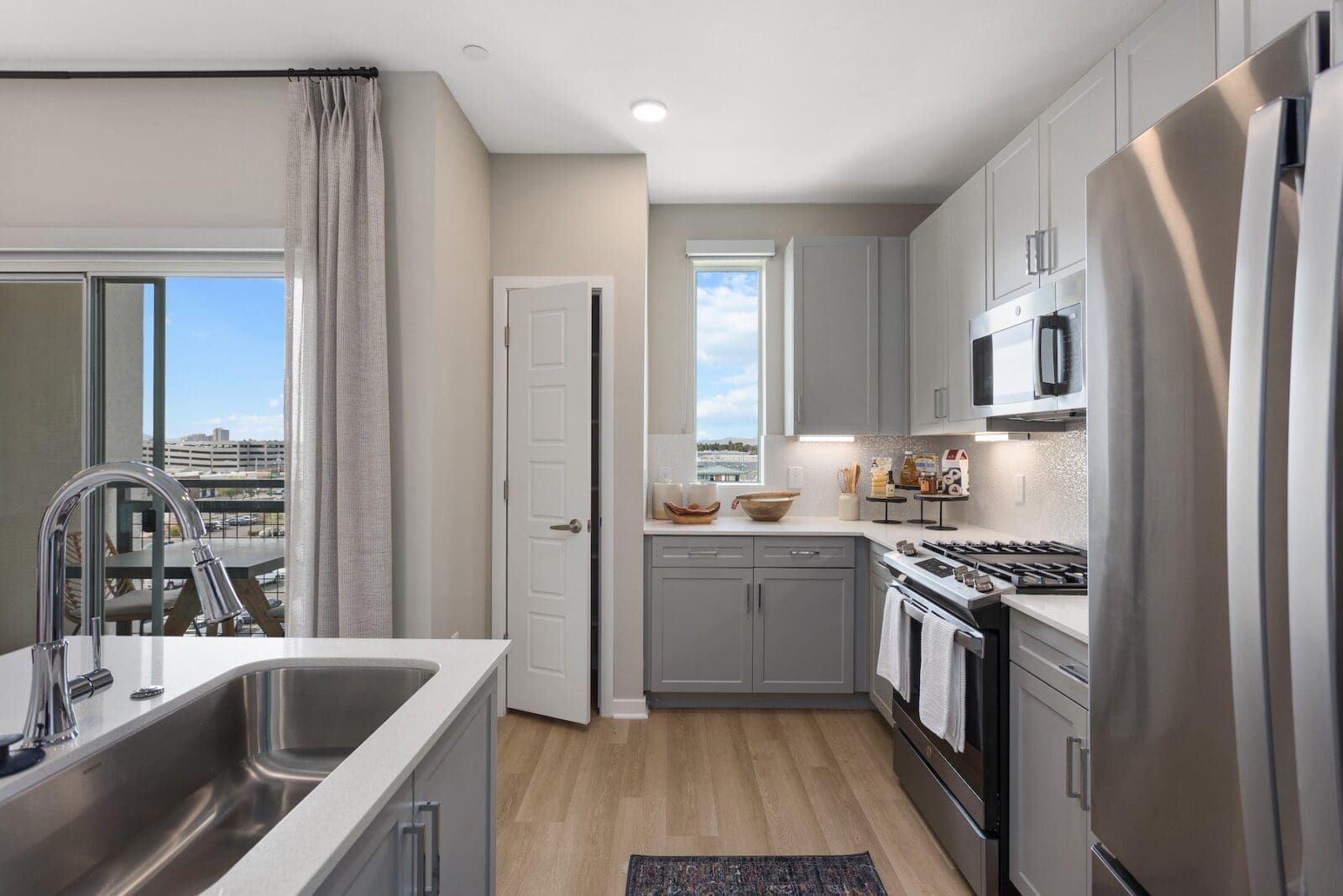 Modern kitchen with stainless steel appliances, gray cabinets, and a large sink at Echo Biltmore in Phoenix AZ.