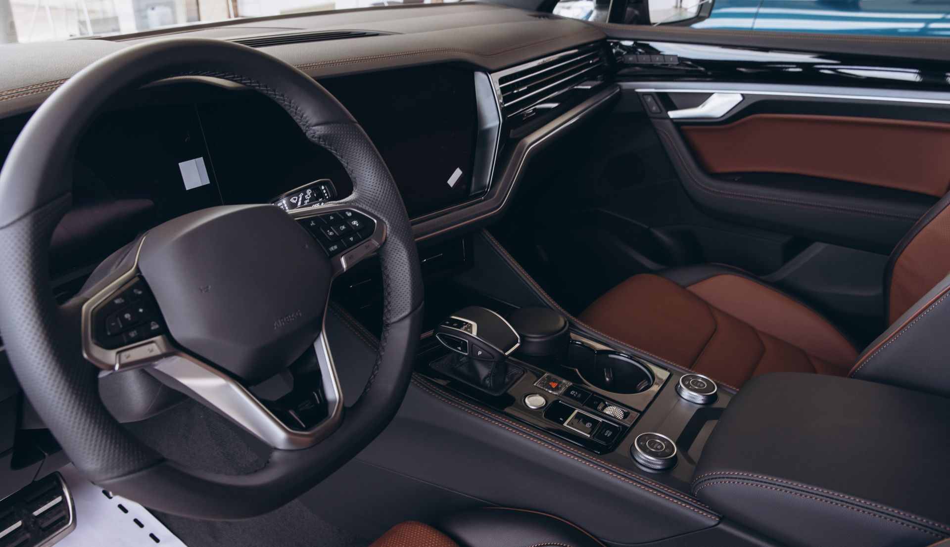 Luxury car interior with black leather seats, steering wheel, and dashboard center console