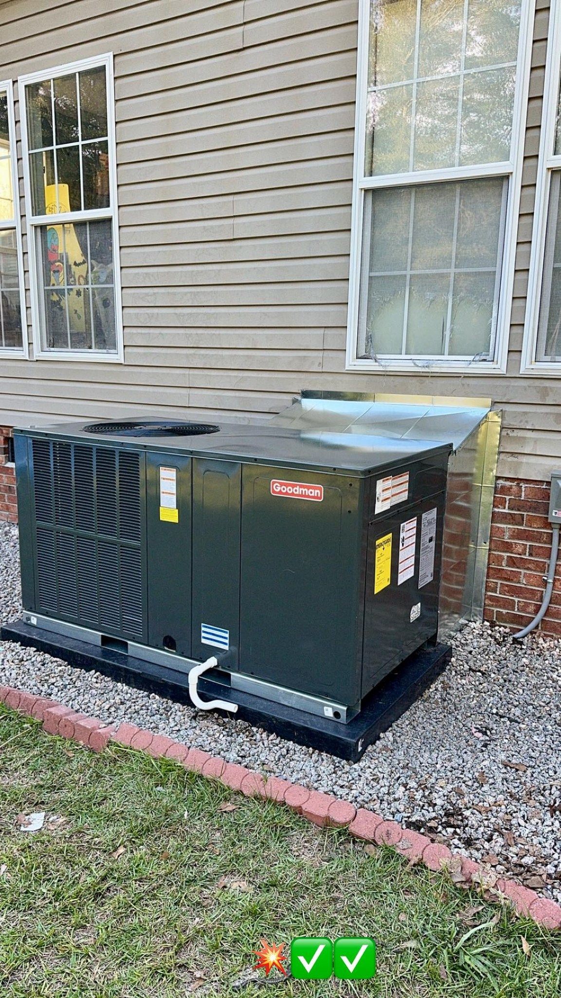 A large air conditioner is sitting on the side of a house.