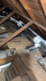 An attic with a lot of pipes coming out of it.