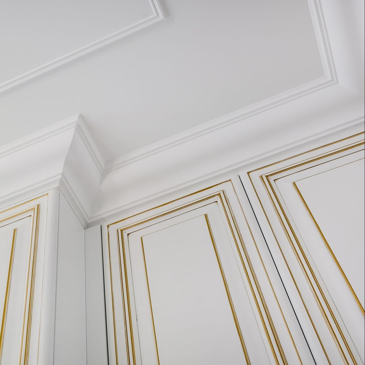 a white wall with gold trim and a white ceiling