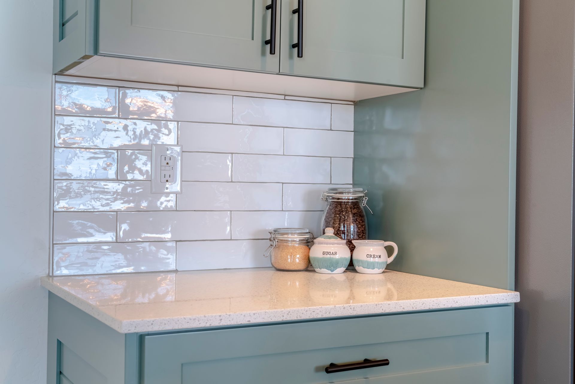 A kitchen counter with a white counter top and blue cabinets.