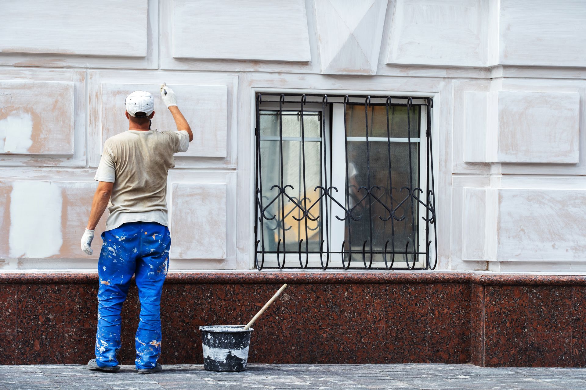 A man is painting the side of a building.