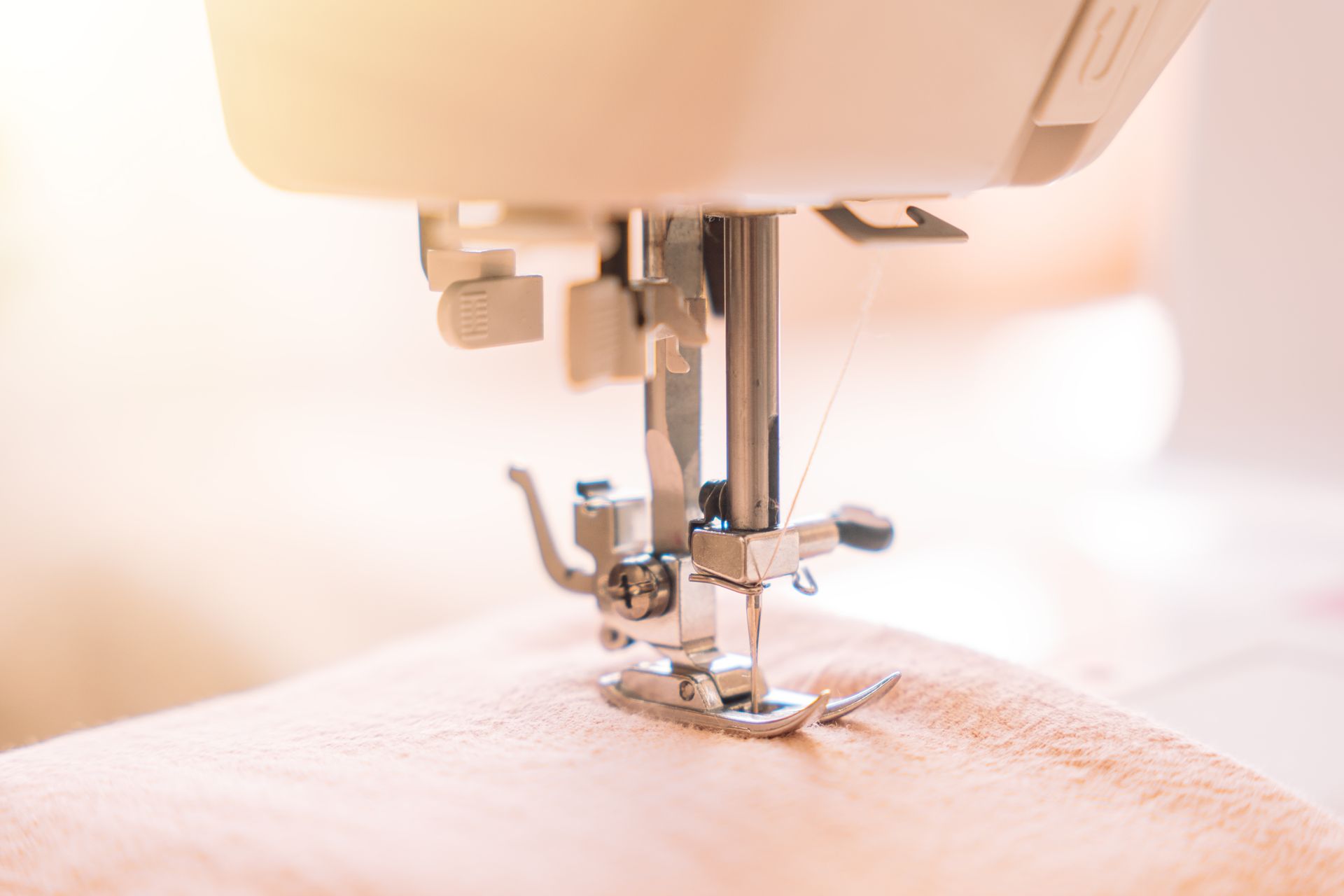 Close-up of a presser foot on a white sewing machine, precision craftsmanship