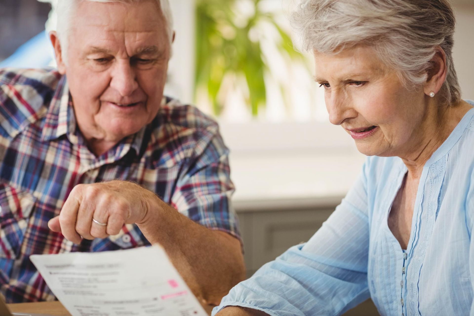 A man and a woman are looking at a piece of paper.