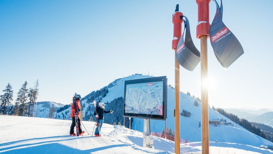 A couple of people standing on top of a snow covered mountain.