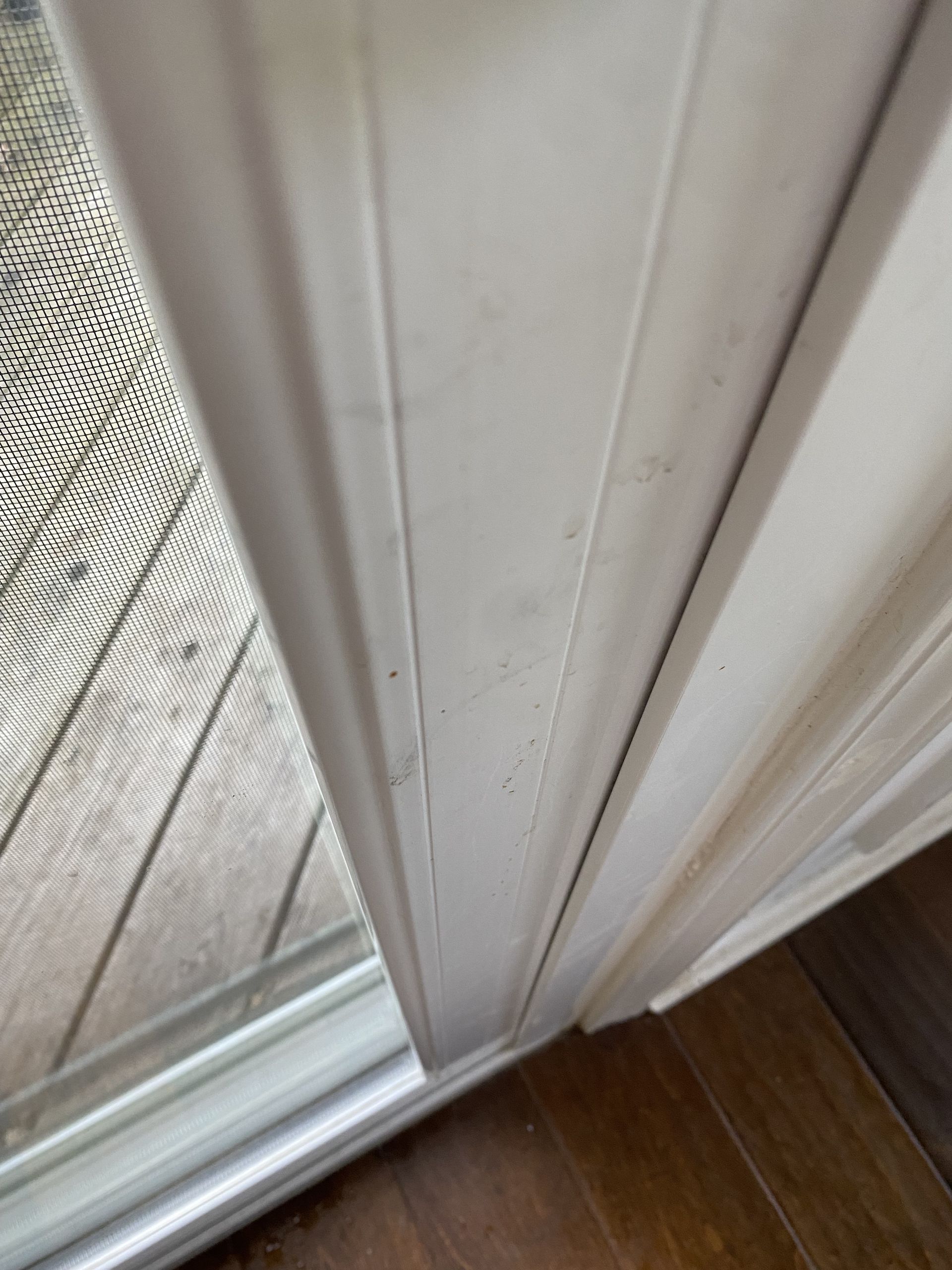 a close up of a sliding glass door with a wooden floor .