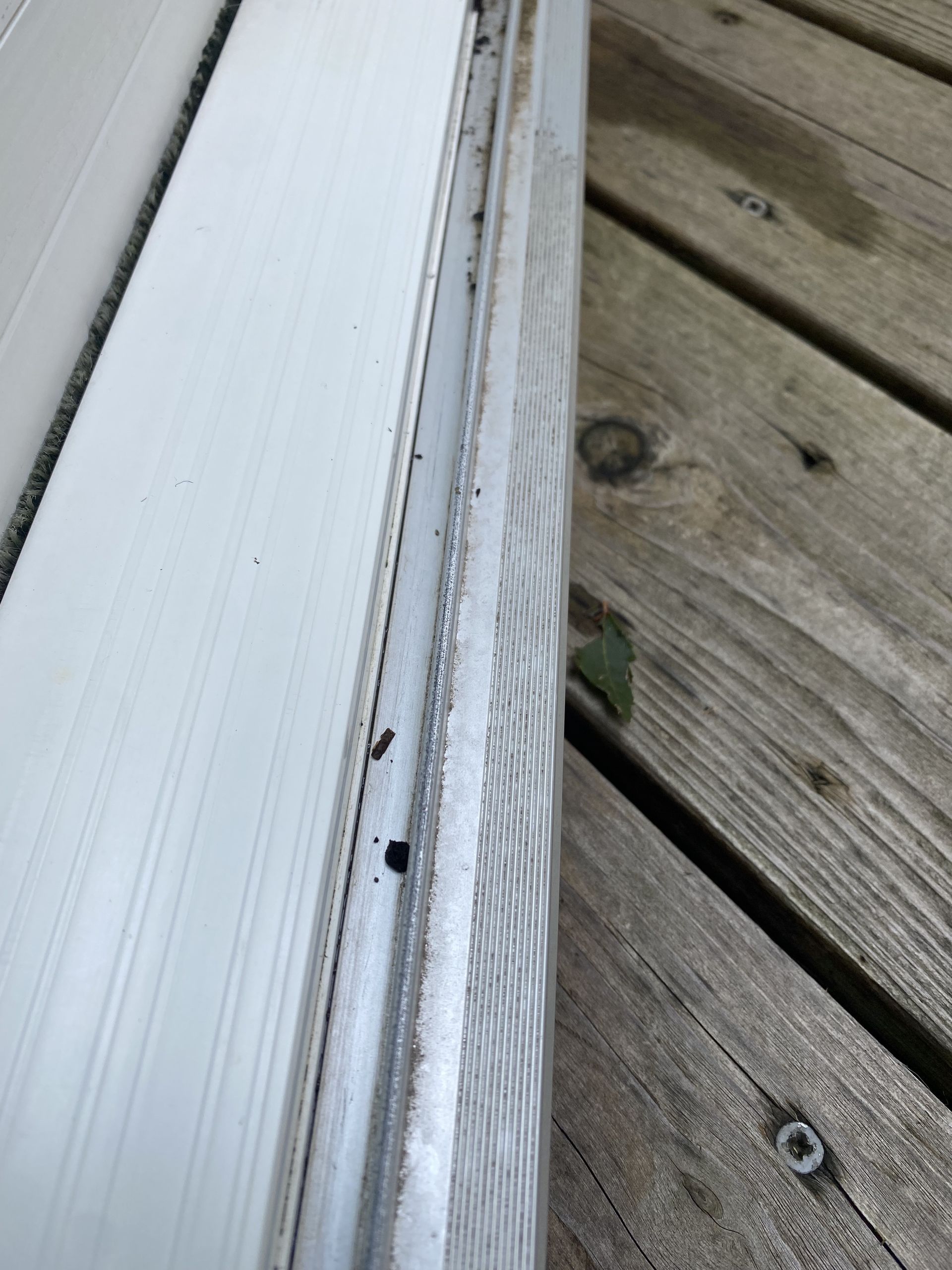 a white door is sitting on top of a wooden deck .