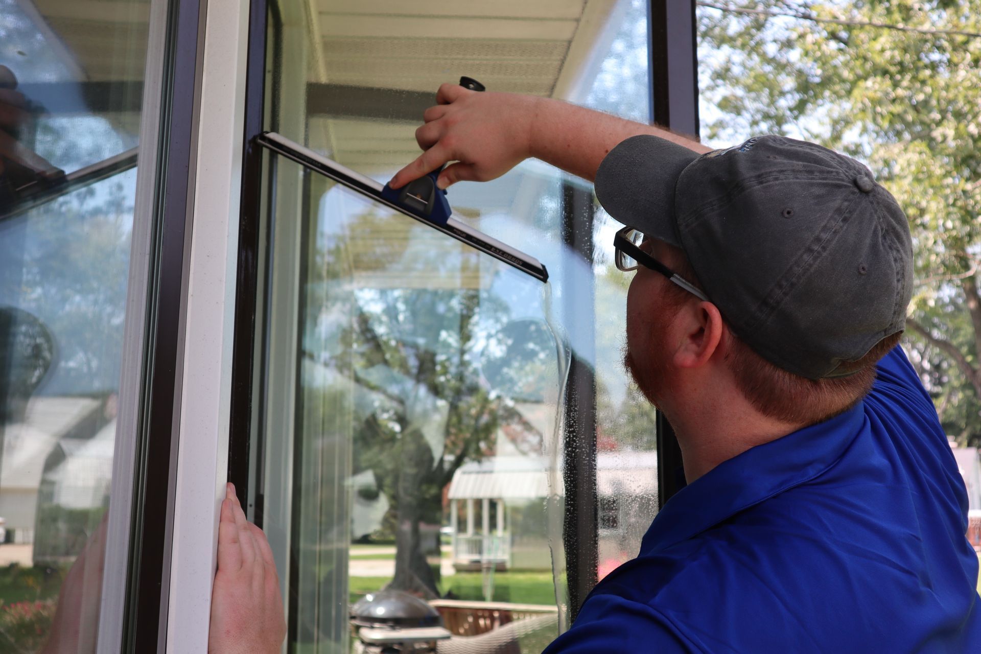 Clearsight Cleaning Services technician squeegeeing storefront window glass for a Tulsa commercial client