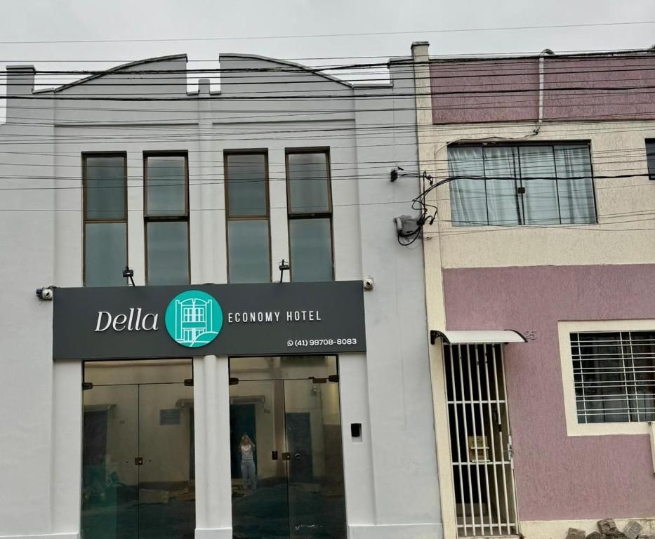 Um prédio cinza de dois andares com a placa 