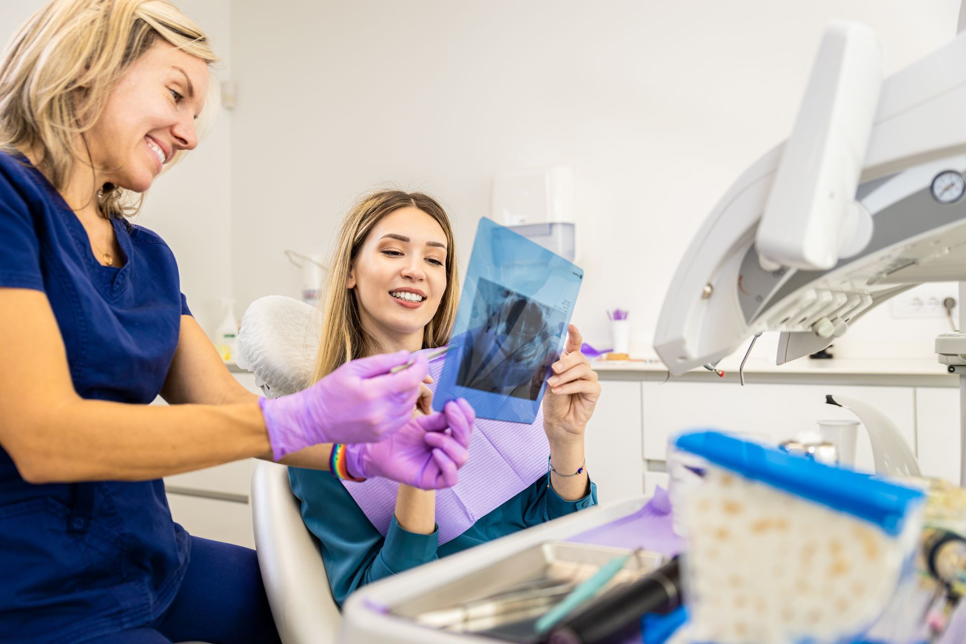 Dentist showing X-ray to smiling patient in a bright dental clinic