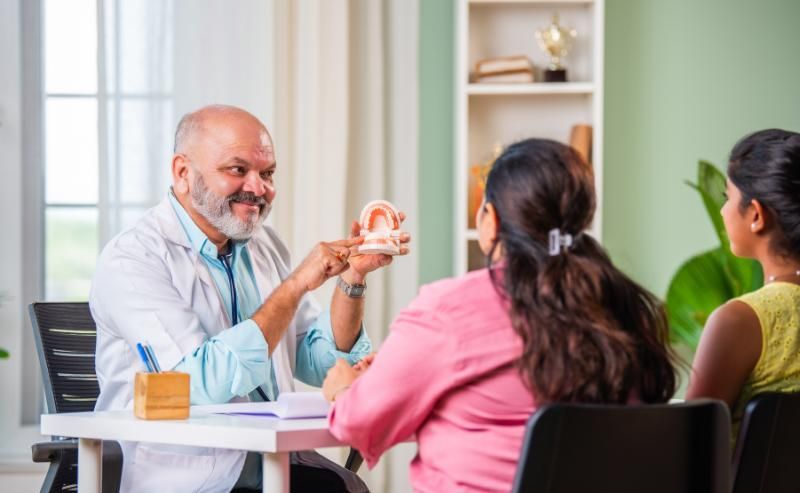 A dentist is talking to a woman during an initial consultation