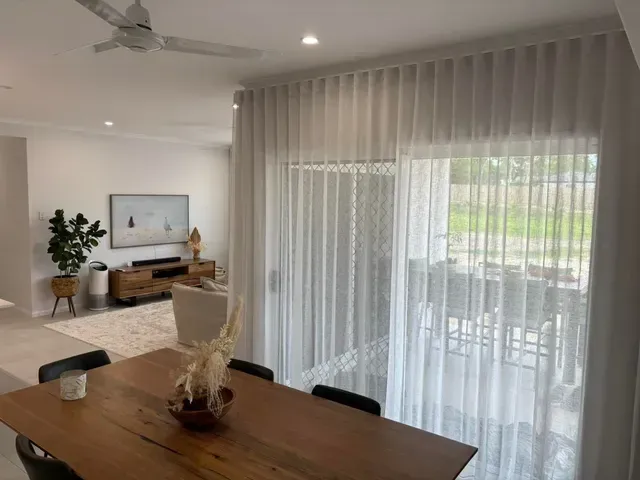 A Living Room With a Couch, Rug, and Sliding Glass Doors — Cover Me NQ in Currajong, QLD