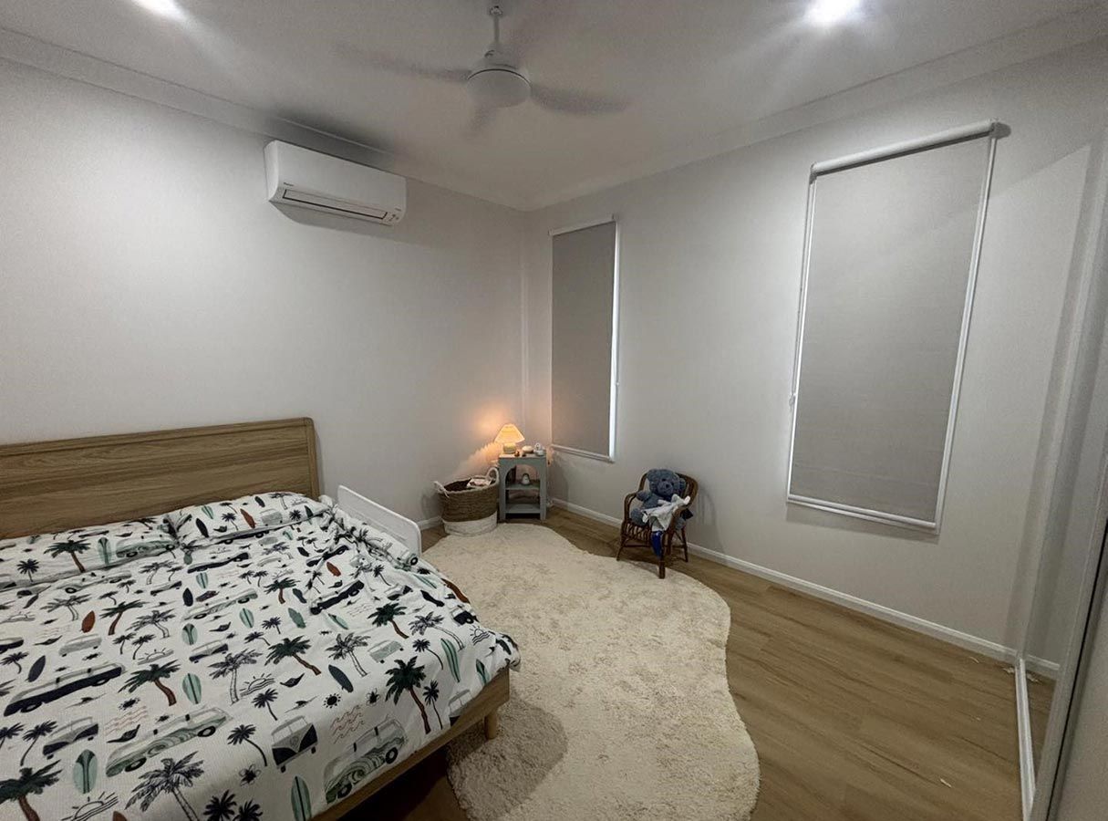 A Bedroom With a Bed and a Ceiling Fan — Cover Me NQ in Currajong, QLD
