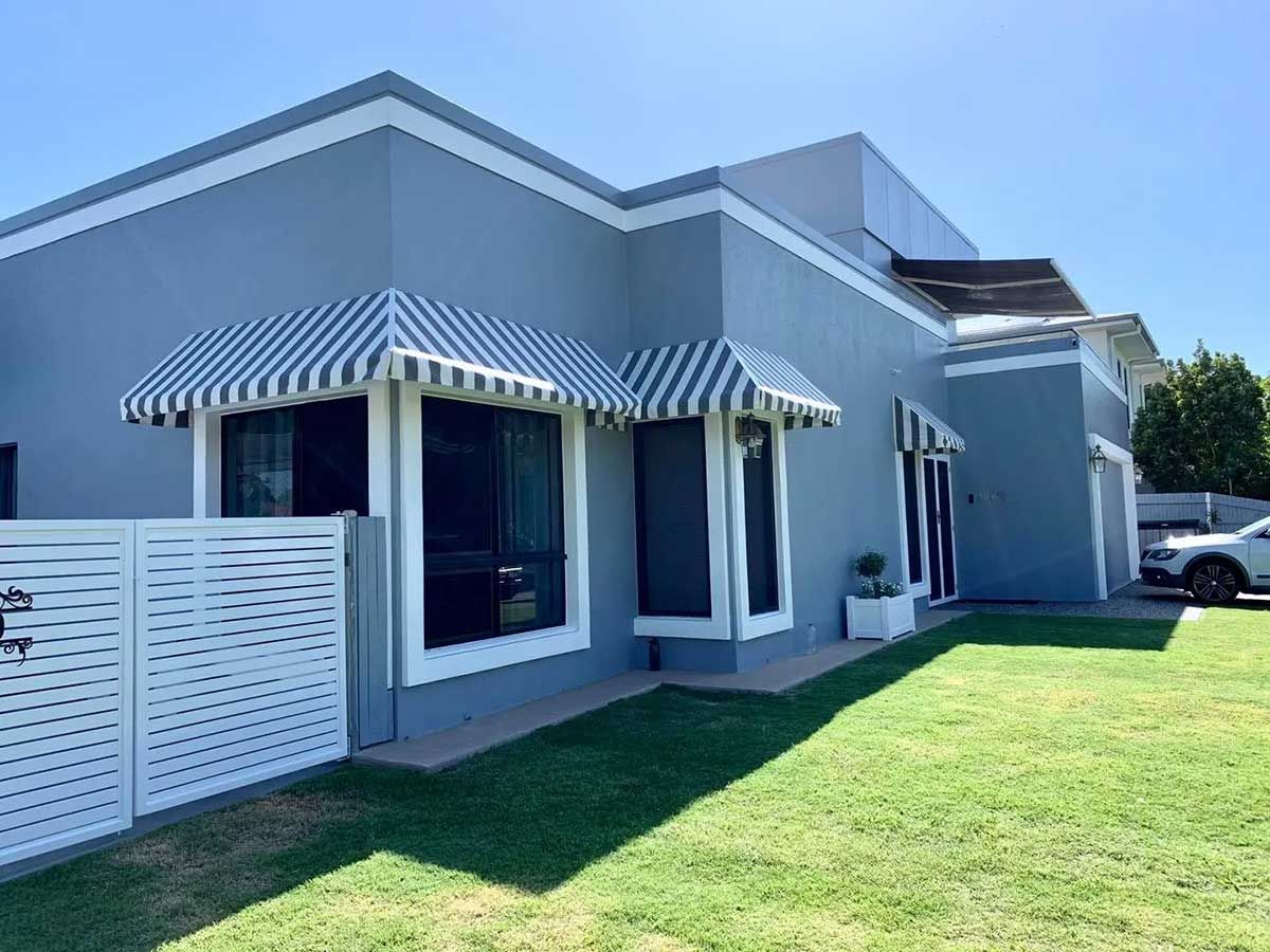 A House With a Striped Awning on the Windows and a Car Parked in Front of It — Cover Me NQ in Currajong, QLD