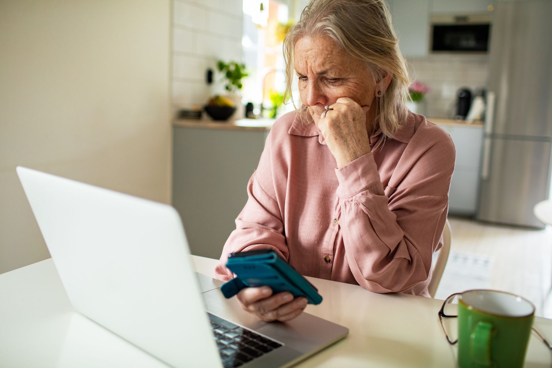 An elderly woman is confronted by an online scam.