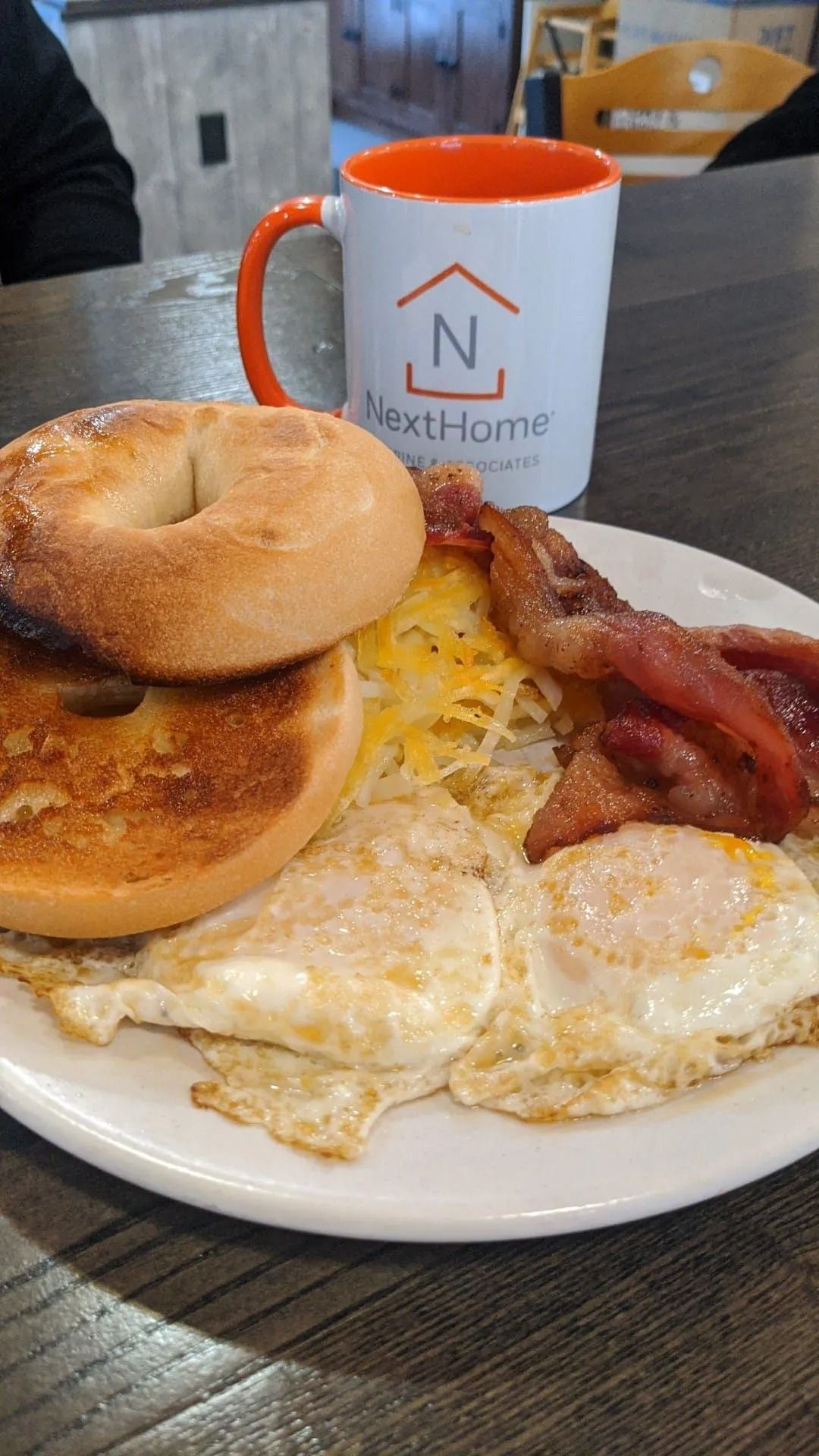 Breakfast plate with eggs, bacon, toast, and a coffee mug on a table