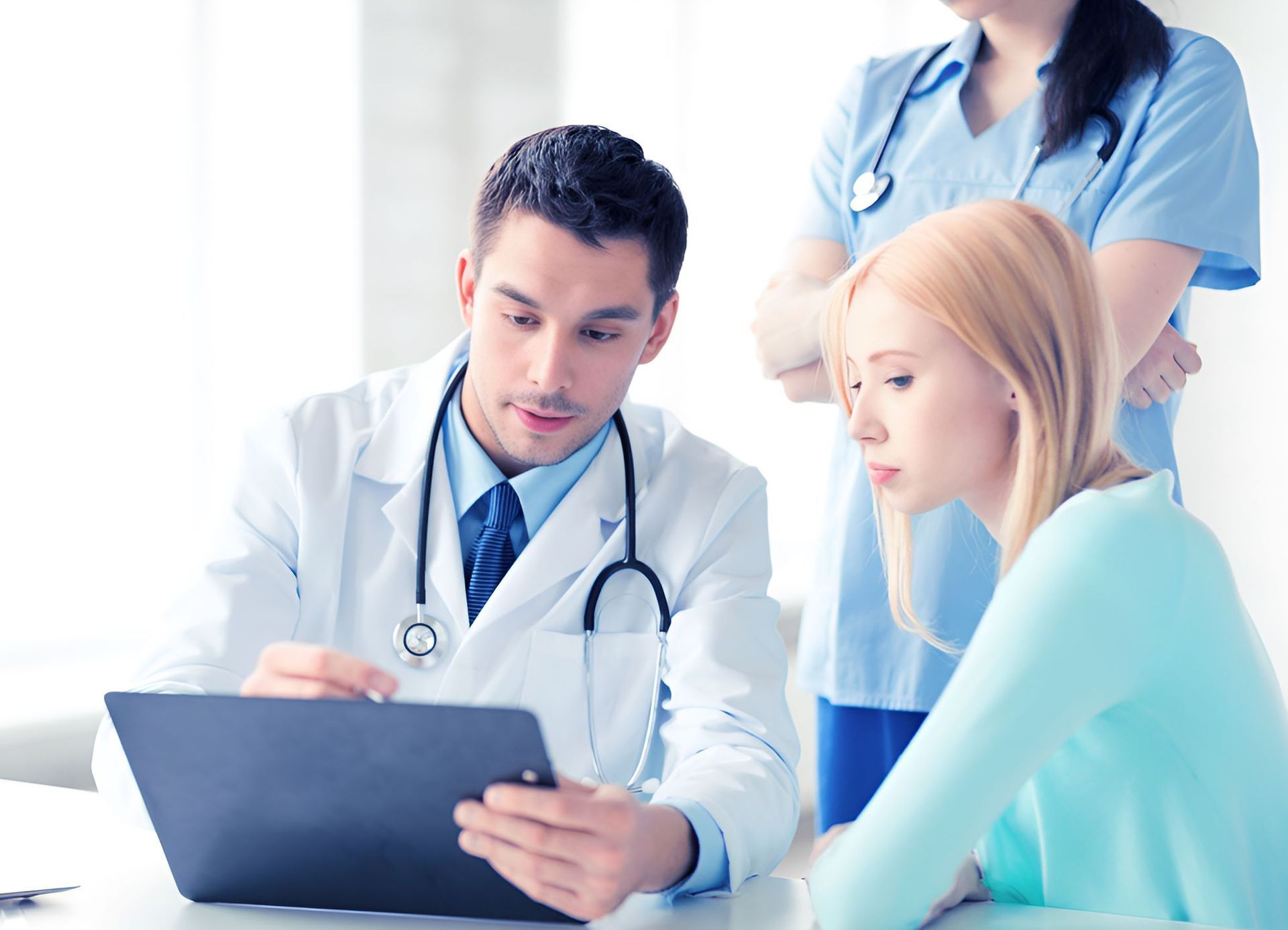 A Doctor and Nurse Are Looking at a Tablet — Newcastle Paediatric Occupational Therapy In Floraville, NSW