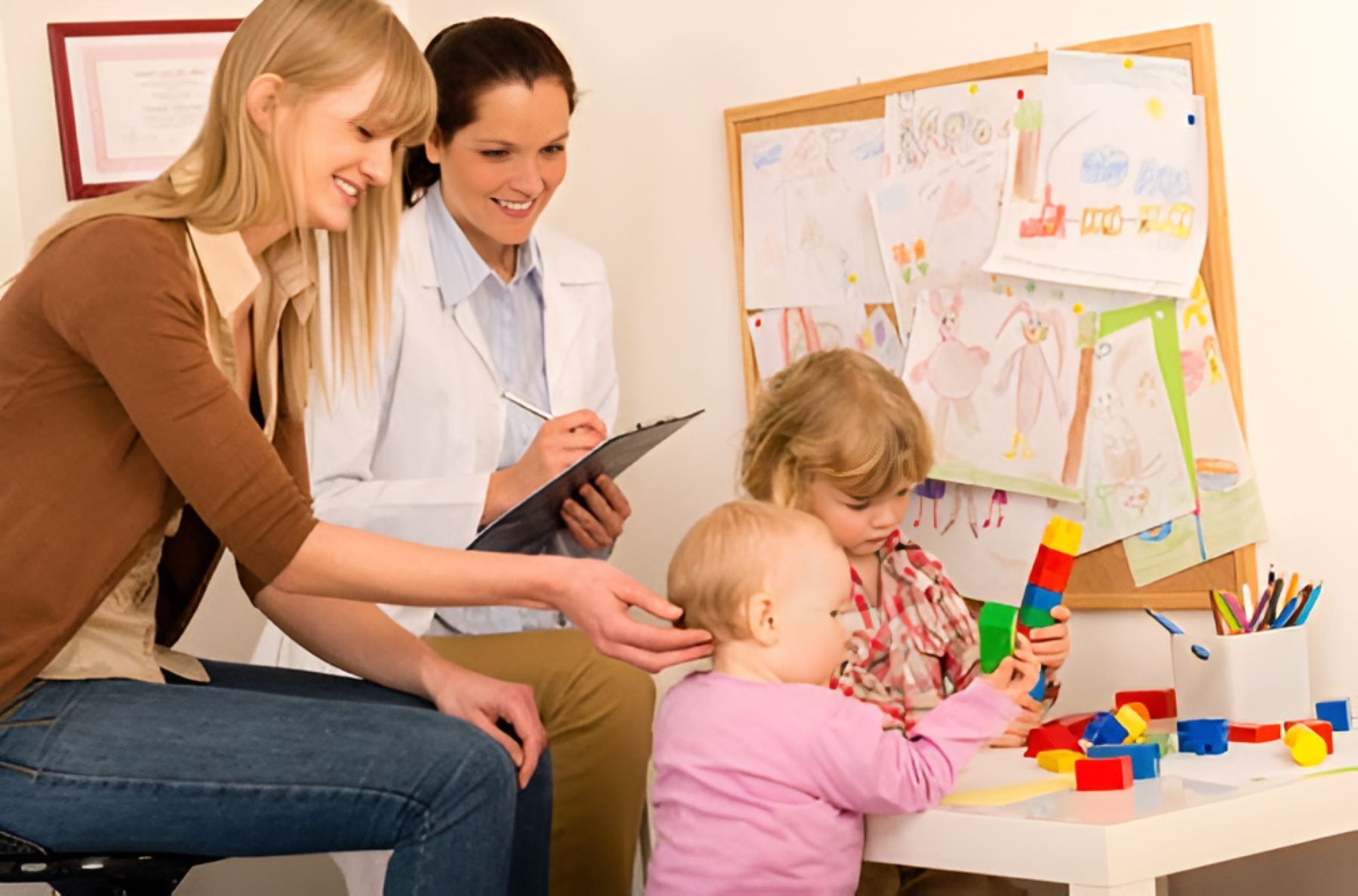 A Doctor is Talking to a Woman and Two Children — Newcastle Paediatric Occupational Therapy In Floraville, NSW