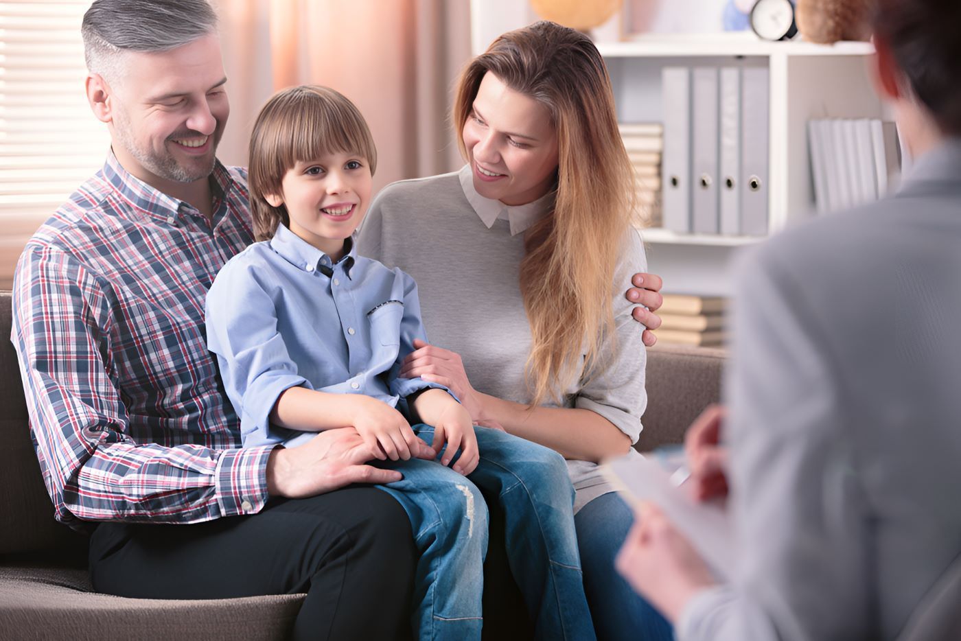 A Family is Sitting on a Couch Talking to a Counselor — Newcastle Paediatric Occupational Therapy in Hunter Region, NSW