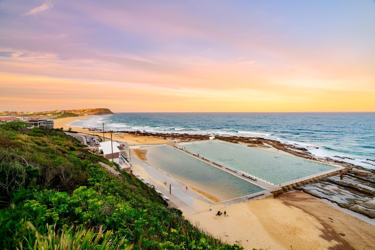 A Large Swimming Pool on a Beach Next to the Ocean at Sunset — Newcastle Paediatric Occupational Therapy in Merewether, NSW