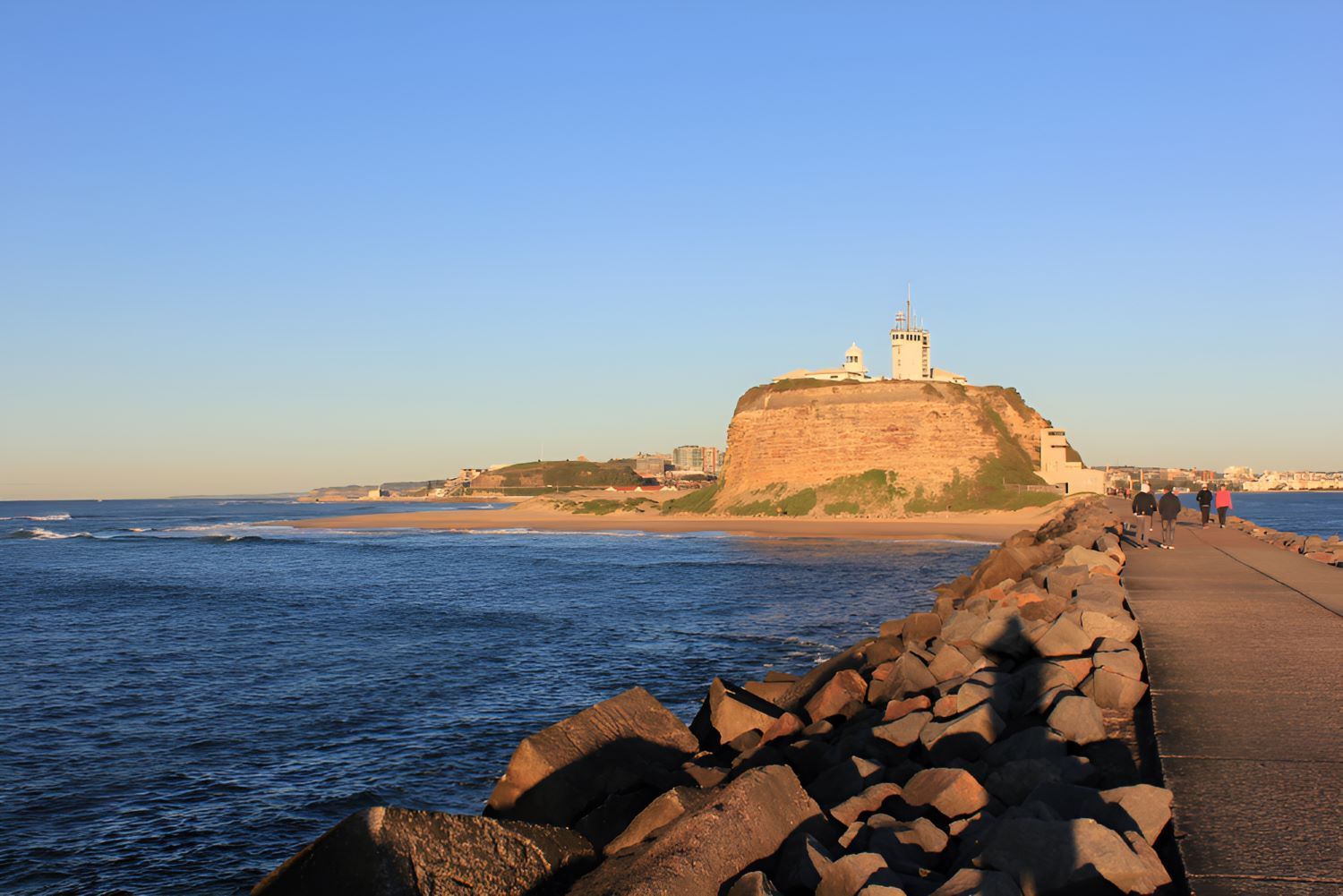 A Lighthouse on Top of a Rocky Hill Overlooking the Ocean — Newcastle Paediatric Occupational Therapy in Mayfield, NSW