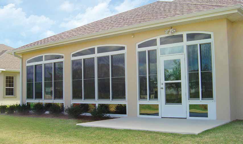 Exterior of a beige house with large arched windows and a white front door under a tiled roof