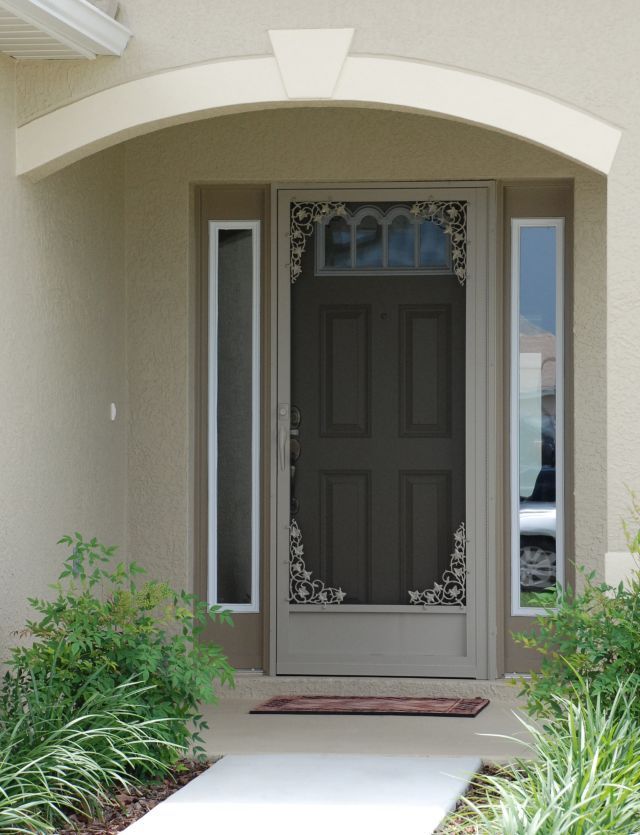 Front entry with gray door, narrow sidelights, and arched white porch