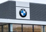 BMW dealership sign on a modern building with black and white exterior panels.
