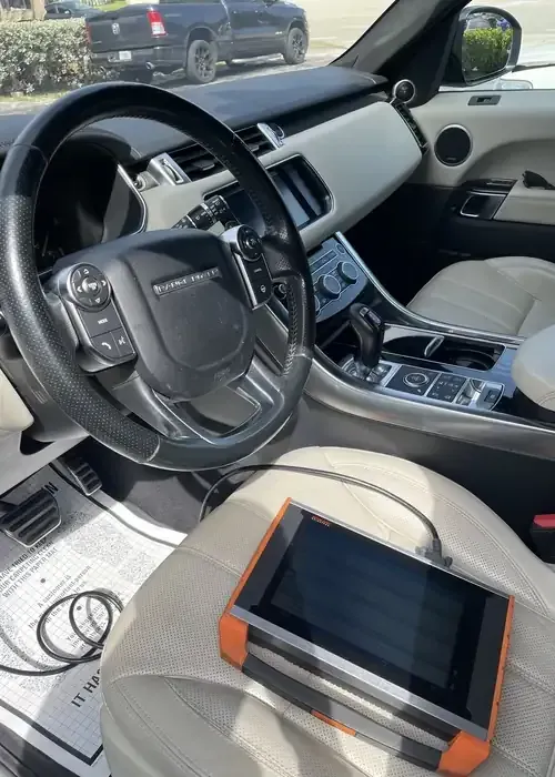 Car interior with steering wheel, center console, and a tablet on the front passenger seat