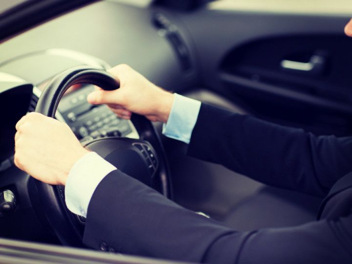 Hands gripping a steering wheel inside a car interior
