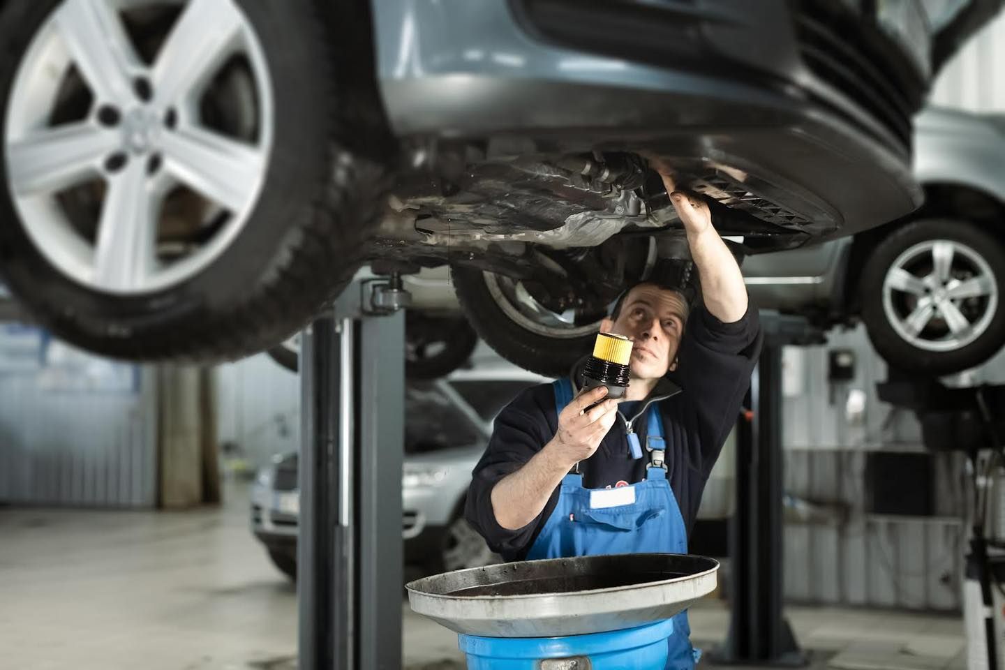 Mechanic changes a car's oil | Old School Automotive & Tire