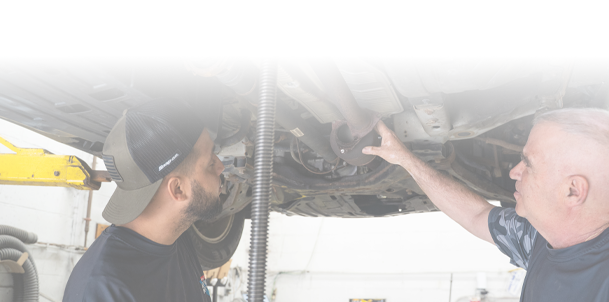 Technicians performing maintenance below vehicle in Fishkill, NY | Jimmy's Auto Outlet