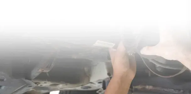 Technician performing maintenance below vehicle | Jimmy's Auto Outlet
