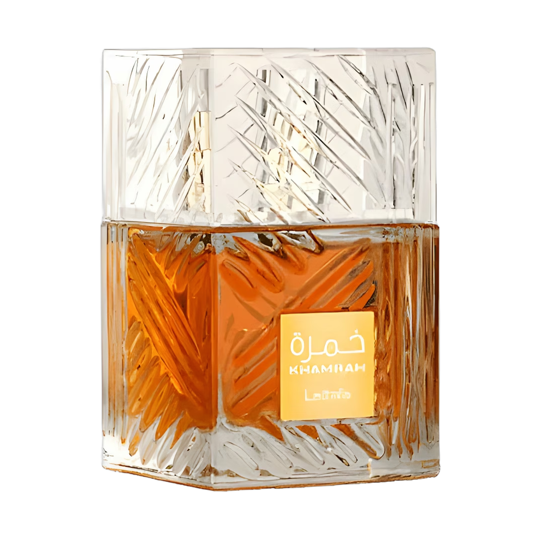 Frasco de perfume cuadrado transparente con líquido naranja y tapón con diseño plateado.