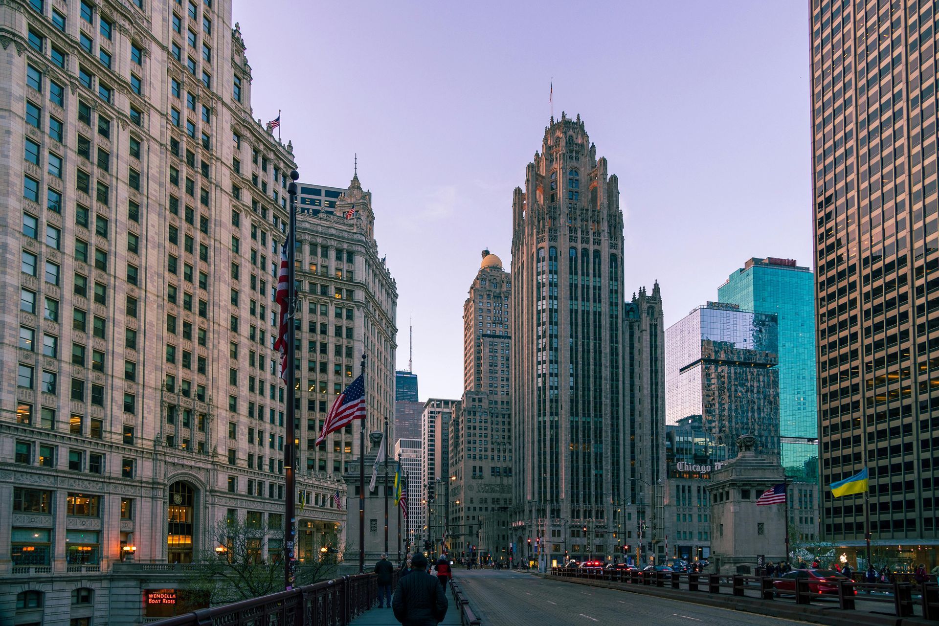 A city street with a lot of tall buildings and a bridge.