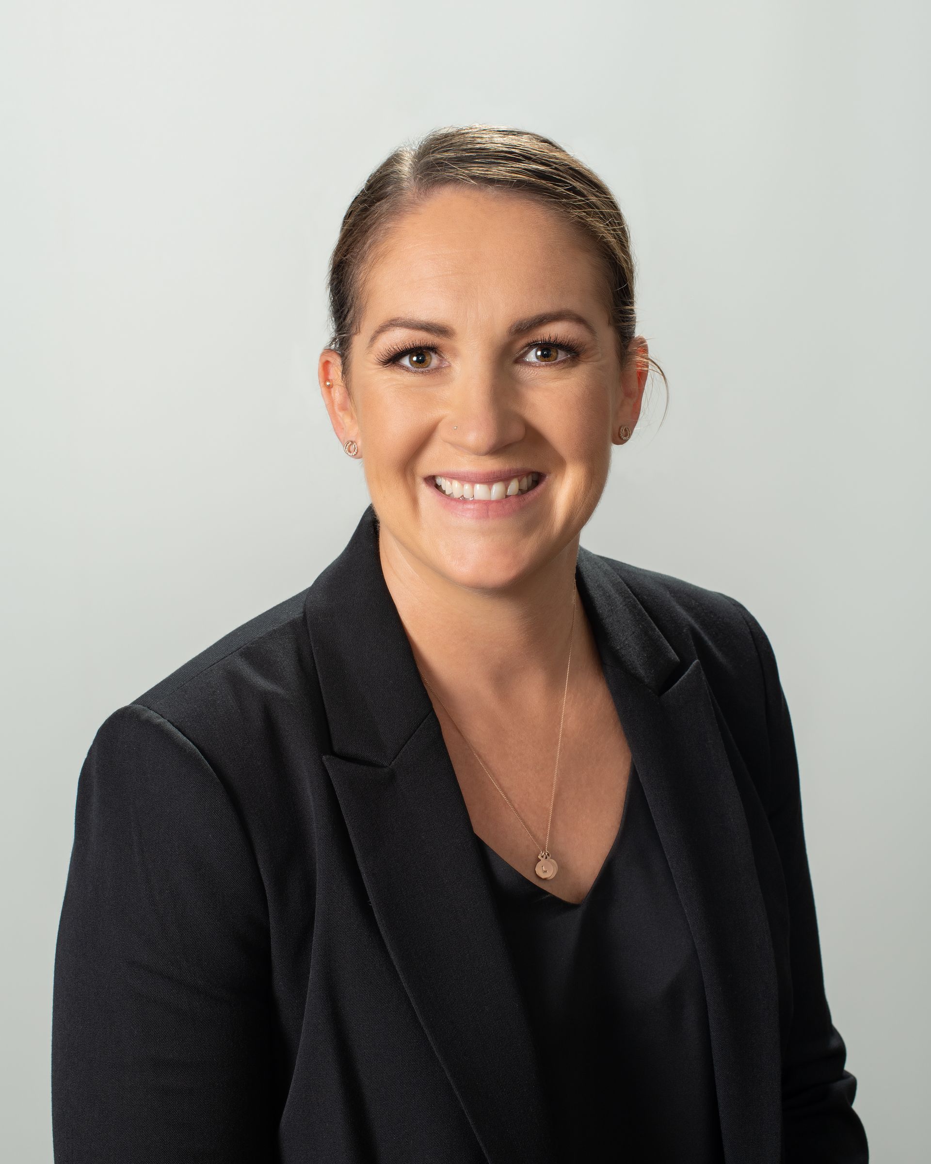 A Woman in a White Shirt in an Office With Her Arms Crossed and Smiling — Dale Wright Portrait Maker in Shepparton, VIC