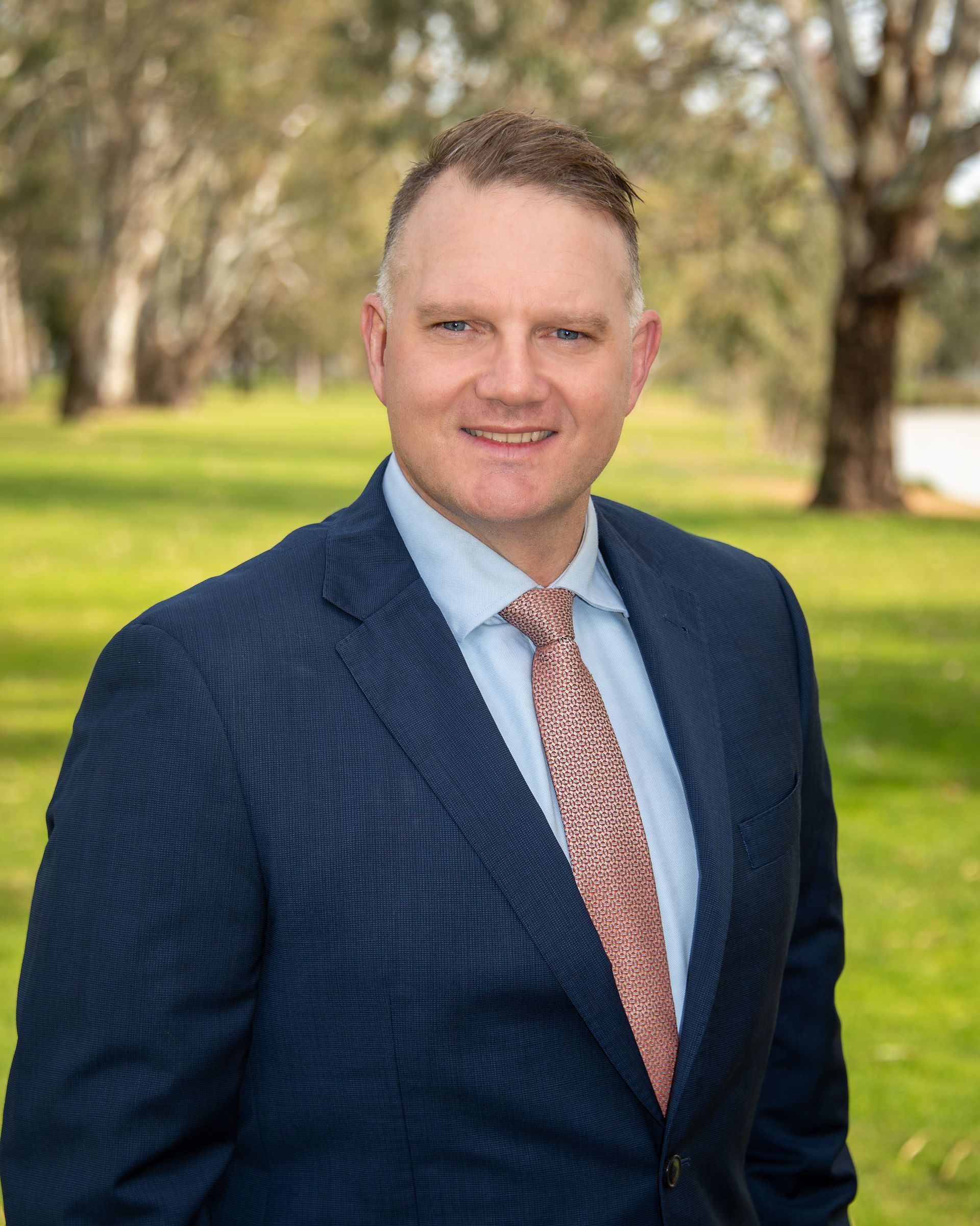 A Man in a Suit and Tie is Smiling and Looking to the Side — Dale Wright Portrait Maker in Shepparton, VIC