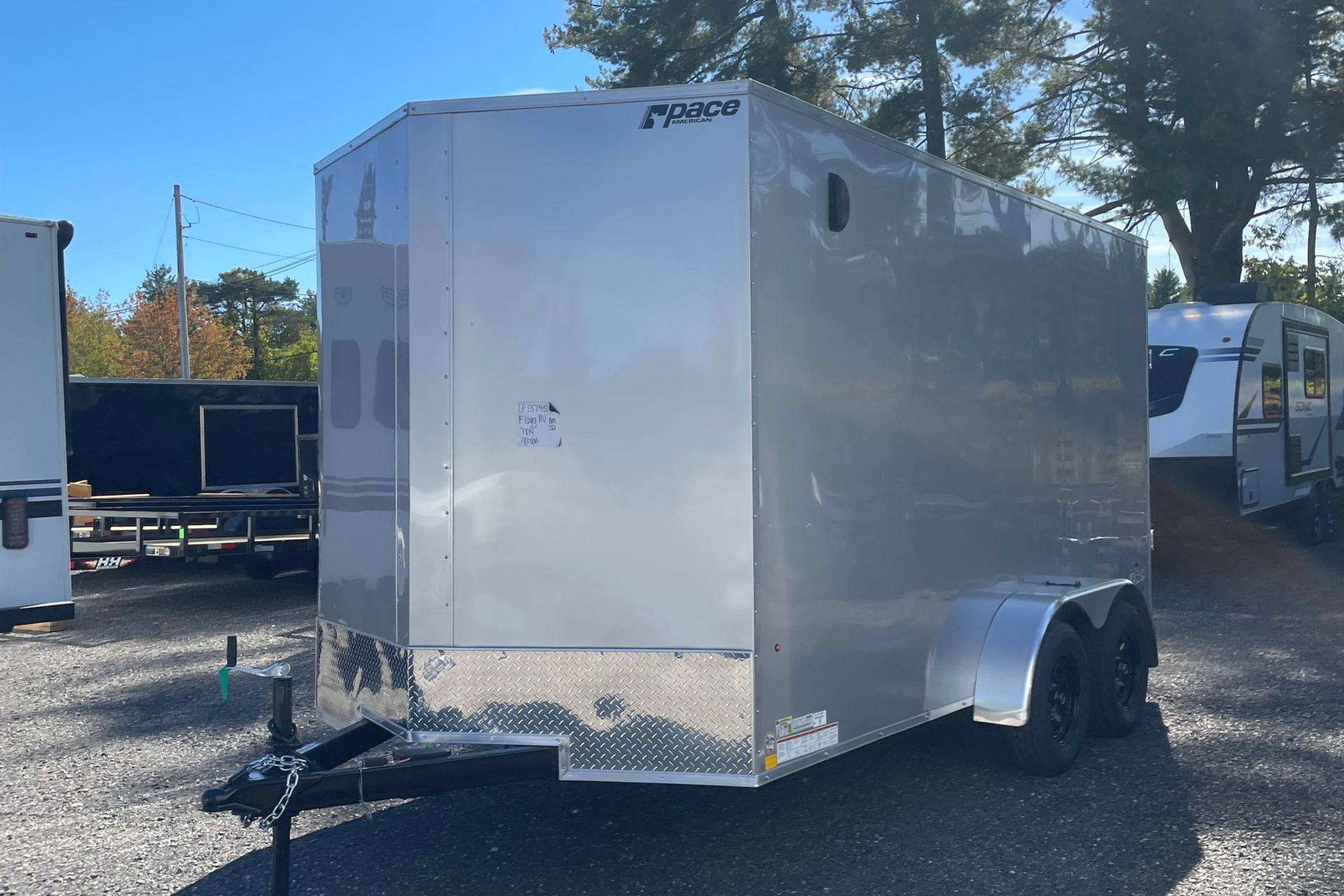 Silver enclosed cargo trailer in a lot.