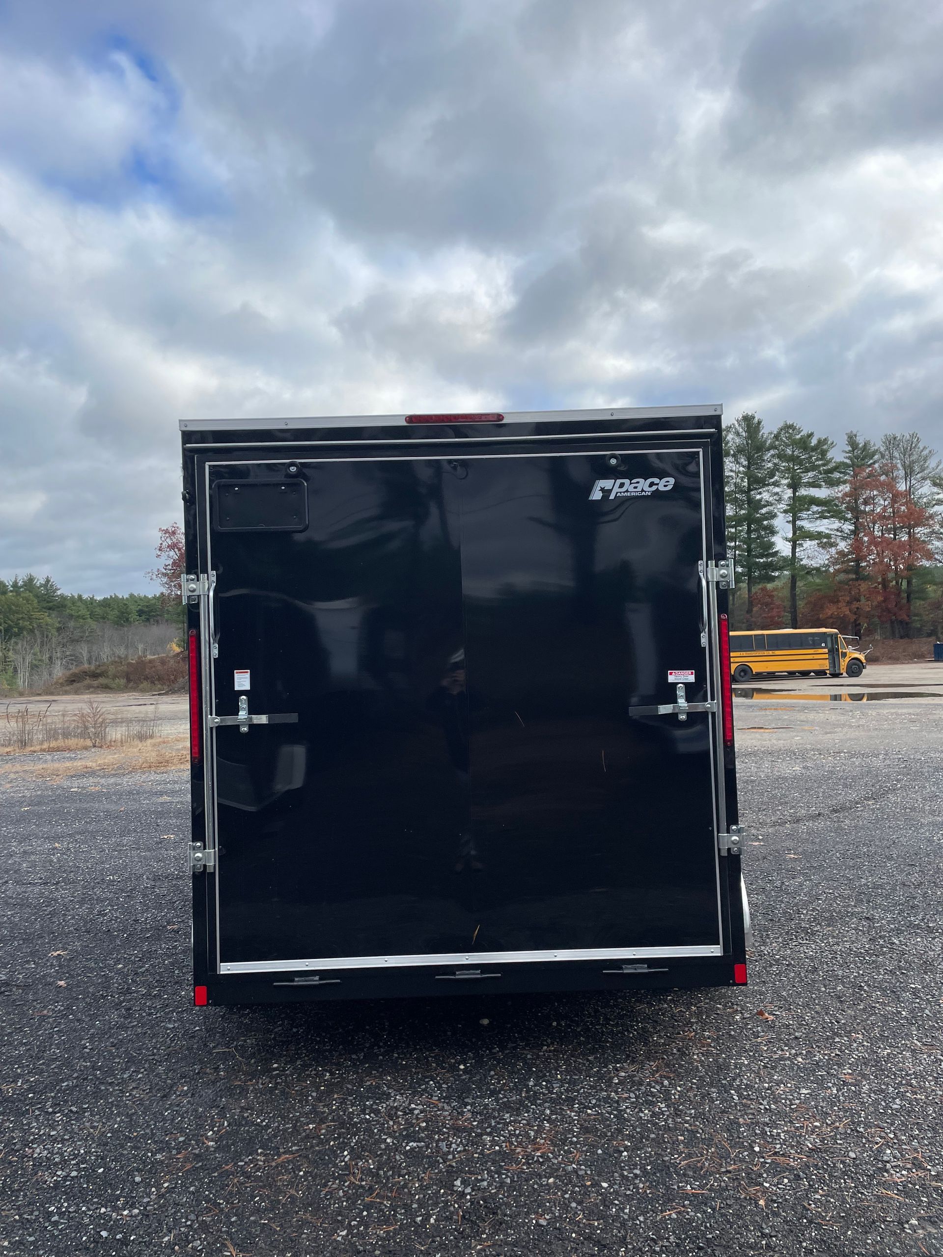Black cargo trailer with closed rear doors.