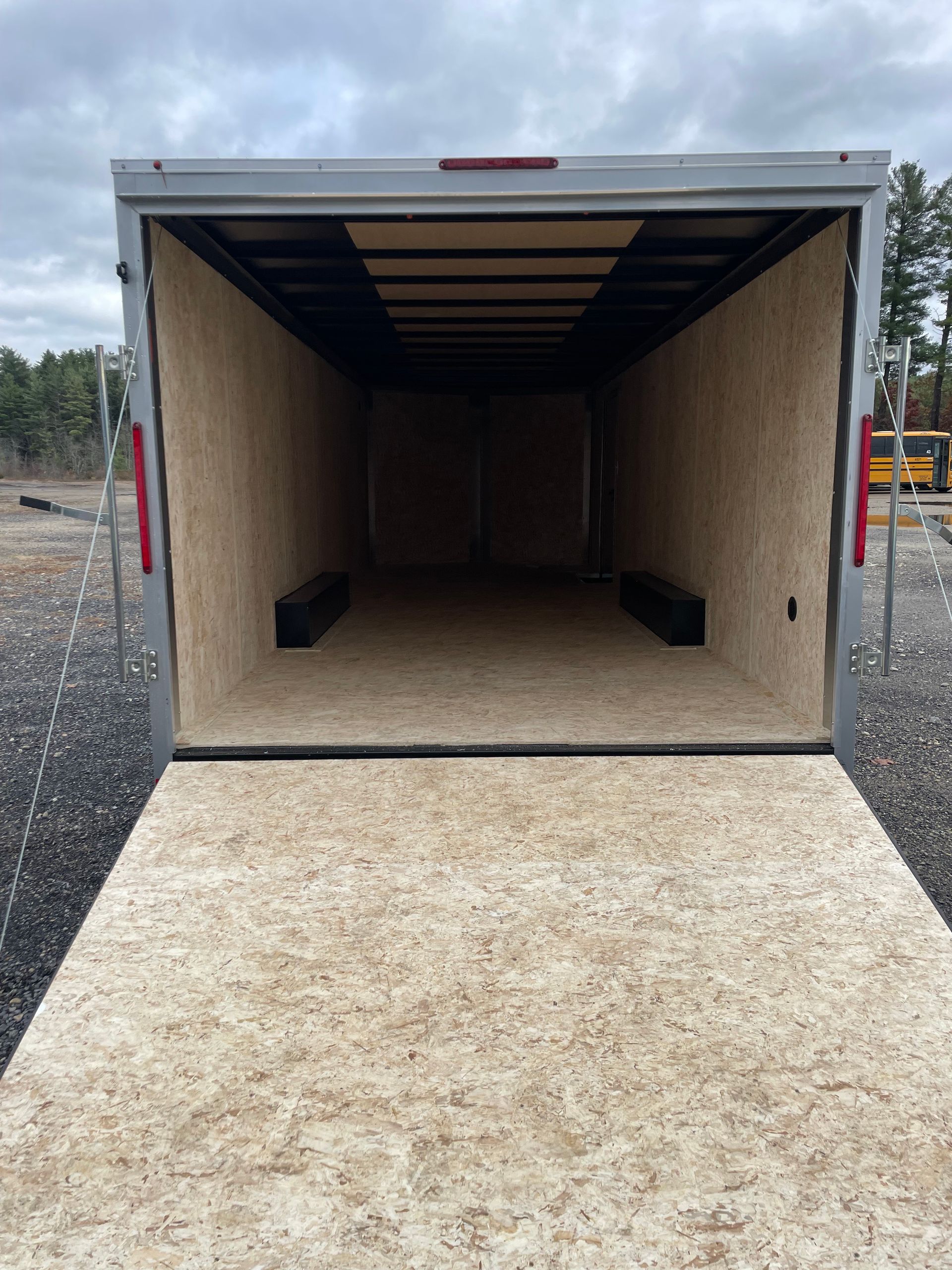 Open empty enclosed trailer with ramp down.